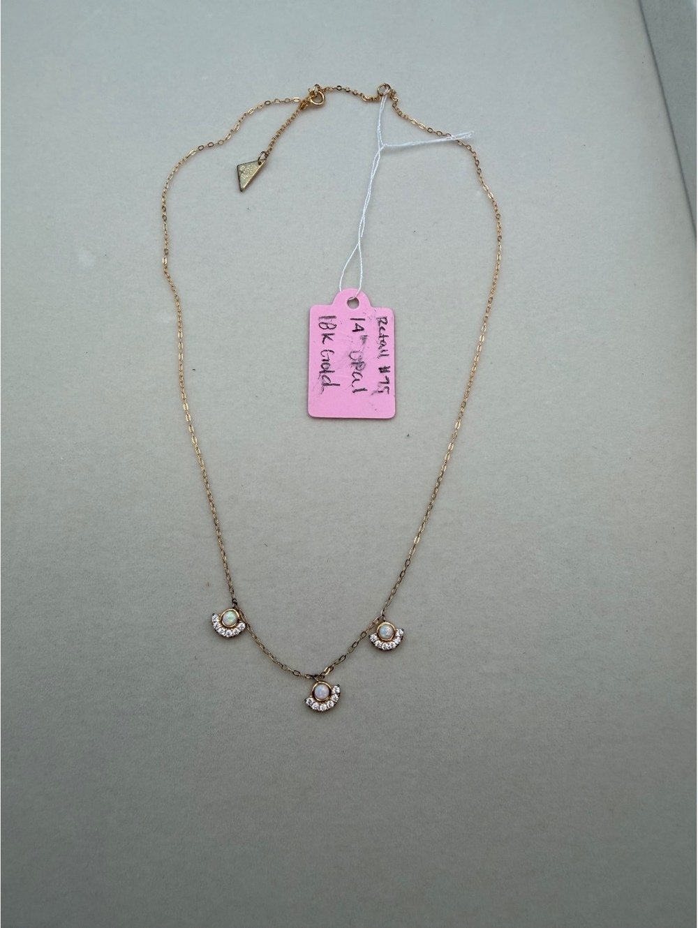 Gold tone necklace with three white cabochon charms